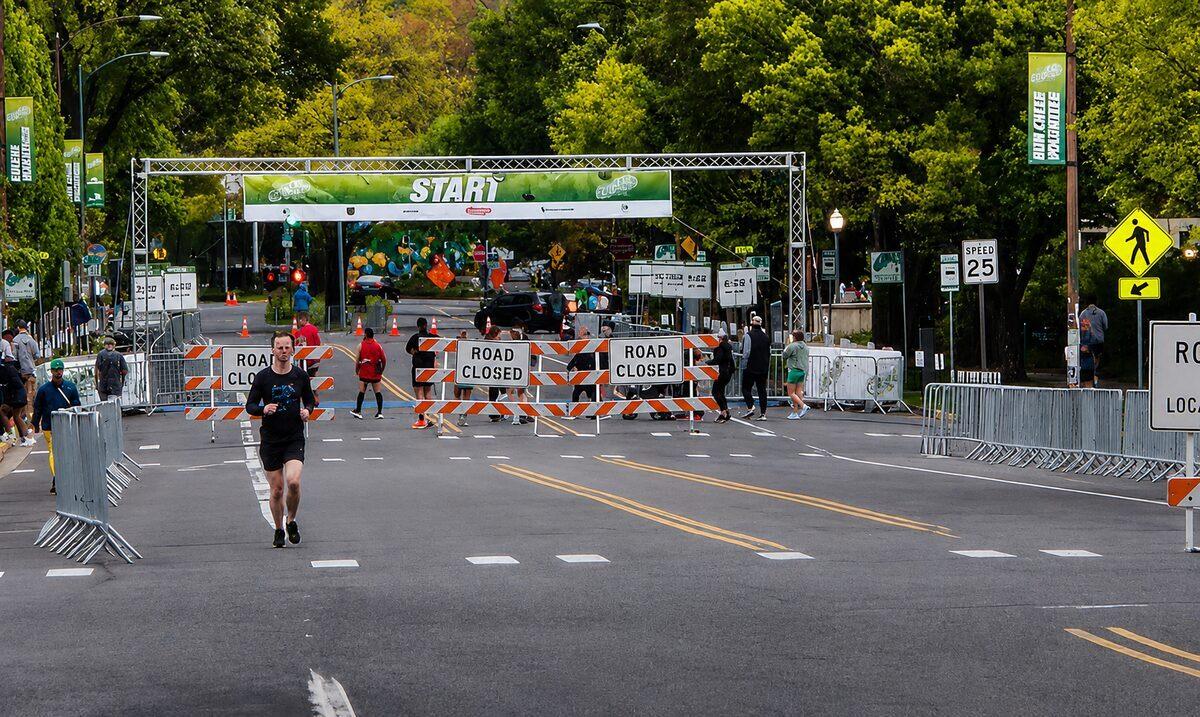 Westates Flagman managing road closures at Eugene Marathon start line with road closed barriers