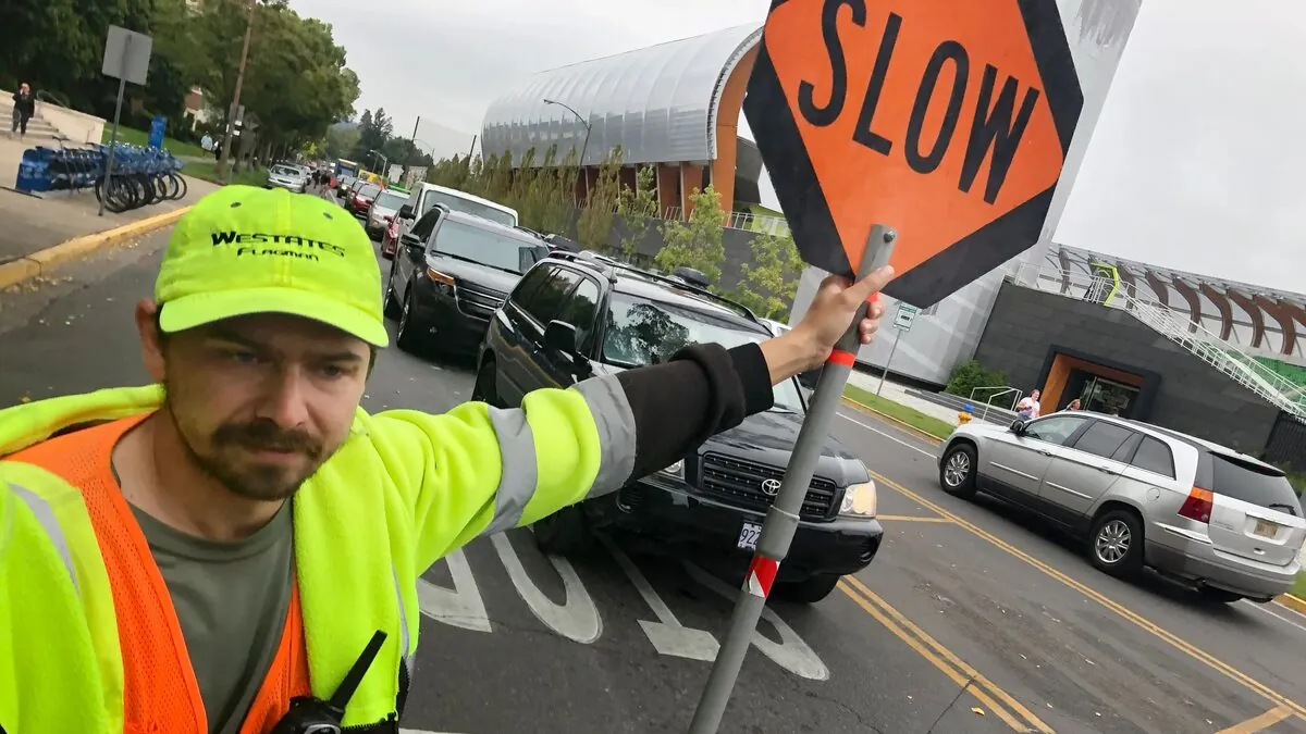 Westates Flagman flagger managing UO Move-In Day traffic on Franklin Blvd Eugene, photo from the Register-Guard, September 2021